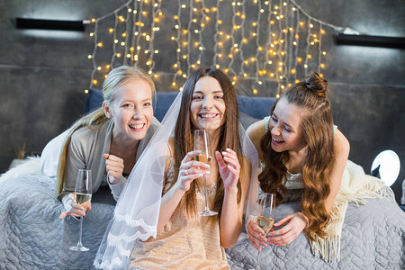 快乐的年轻女子在单身派对上喝香槟图片