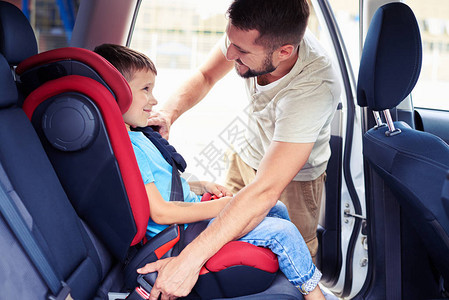 坐在汽车座椅上的小帅儿子的侧边景色父亲把小帅儿图片