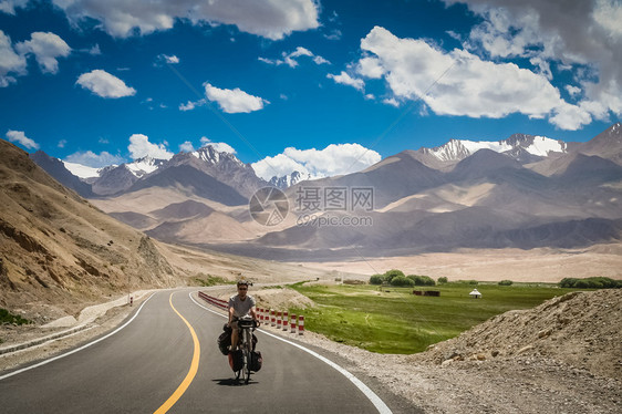 卡拉库鲁姆高速公路骑自行车的单身男骑自行车者Karak图片