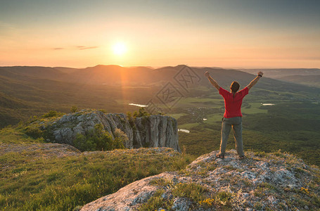 活跃的徒步男子举起手站在山上欢迎克里图片