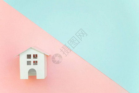 粉红和蓝色面纸彩色几何平板固定背景的微型白色玩具房抵押财产保险梦图片