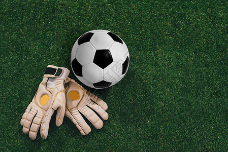 草地上的足球和守门员手套图片
