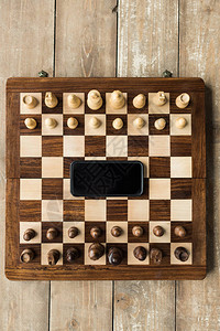 用智能手机和木表面象棋碎片的象棋图片