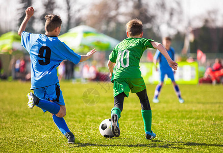 孩子们在生动的绿草场上踢足球背景是足球场足球背景图片
