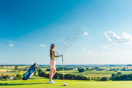 身穿现代高尔夫服装的合适女侧面观背景图片