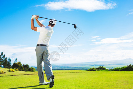 男子在美丽的阳光绿色高尔夫球场打高尔夫球用一号木从发球台沿球道图片