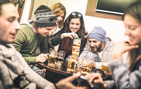快乐的朋友在酒吧喝啤酒时玩桌游背景图片