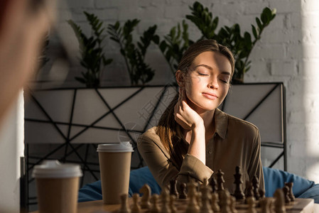 美丽的年轻女子下象棋而阳背景图片