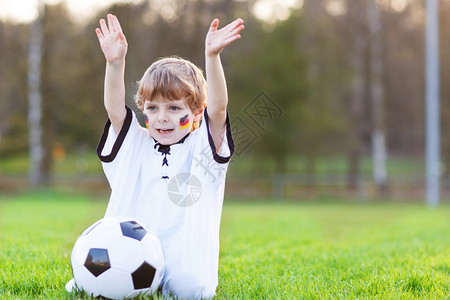 欢乐的球迷儿童在户外观看足球或足球比赛图片