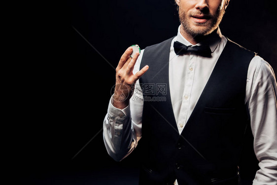 穿着正装的男人拿着被黑色隔离的扑克筹码的剪影图片