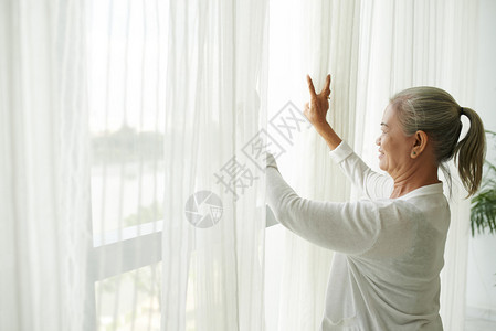 成熟的女站在窗边图片