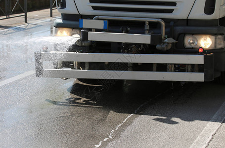 清洗街道的卡车强大的水溅背景图片