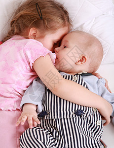 可爱的姐在床上抱着小婴儿图片