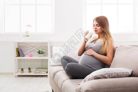 孕妇喝杯牛奶年轻的期待金发女郎享受健康的饮料医疗保健营养维生图片