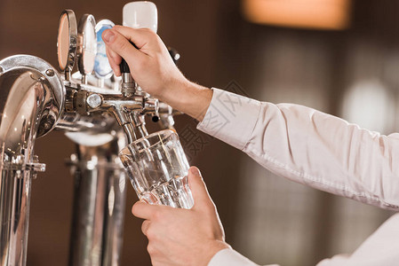 酒吧男士去倒啤酒从啤酒龙背景图片