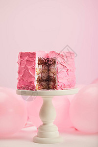 蛋糕摊的蛋糕柜上粉红色气球旁边有图片
