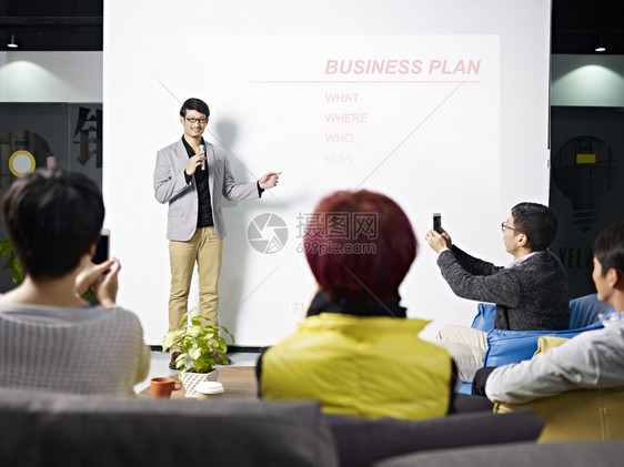 年轻的亚洲企业家介绍新项目的商业计划观图片