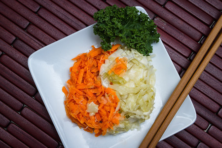 白色盘子上配有发酵蔬菜的白盘装在图片