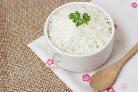 熟米饭茉莉香米熟茉莉香米和茉莉香米粒在黄麻布上的碗背景图片