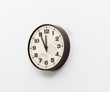 办公室墙上的棕色简单的塑料墙钟表和时间用完的概念背景图片