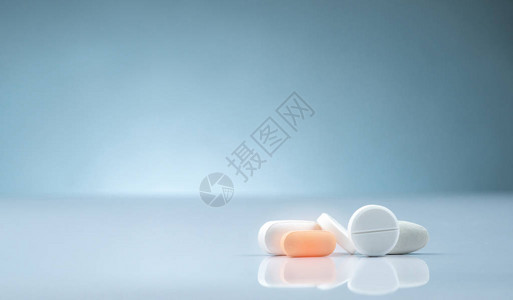 药房店产品一堆橙色和白色药片在渐变背景上不同大小和形状的片剂丸医药行业医院里的药图片