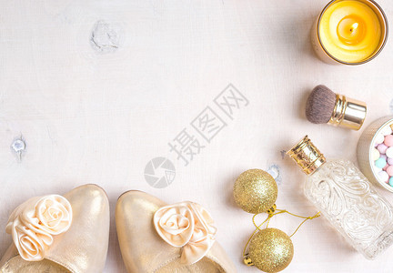 彩色的化妆品装饰用金高跟鞋金闪亮的圣诞花球香水瓶烧蜡烛陨石粉和刷子图片