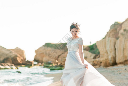 美丽的新娘穿着豪华婚纱与海边的花束海边的婚礼新娘在婚礼地点附图片