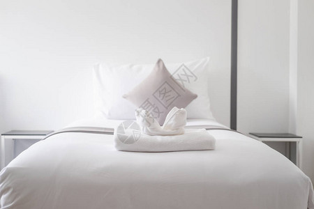 酒店卧室单人床上的白色清新毛巾图片