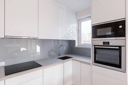 现代厨房配有白色橱柜高光瓷砖新图片