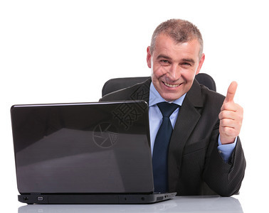 坐在笔记本电脑上用白色背景向相机展示拇指标图片
