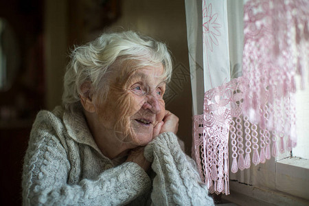 一位白头发的老年妇女坐在窗图片