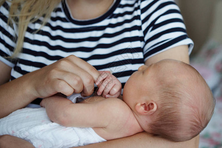 疯抢七天一位年轻母亲正在母乳喂养她七天大的女儿背景