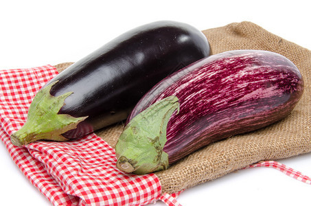 粗麻布袋上的紫色和黑色茄子与白色隔离图片