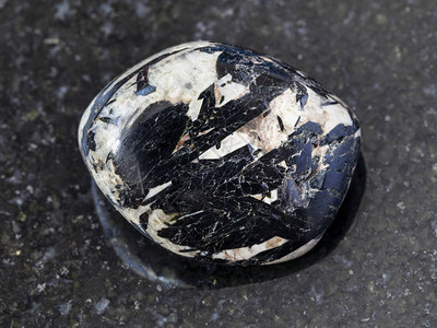 俄罗斯科拉半岛洛沃泽罗地块深色花岗岩背景上抛光微斜石中天然矿物岩石标图片