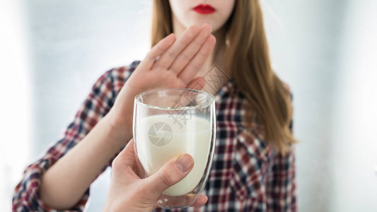 乳糖不耐症乳制品不耐症的年轻女孩拒绝喝牛奶浅景深选择地图片