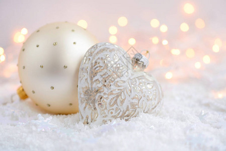 雪上和圣诞灯光上的圣诞装饰品圣图片