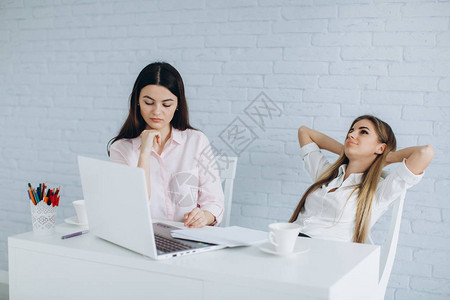 两名疲劳的女商人在白净图片