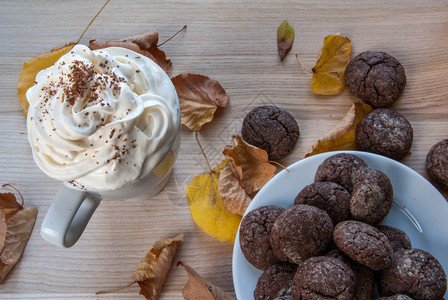 秋季小吃热巧克力配生奶油和香浓的巧克力曲奇在一张木桌的背景下图片
