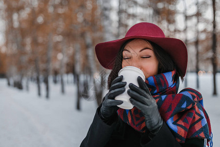女人在寒冷的白天喝着大杯热外送饮料图片
