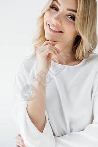 穿着白衣的美丽微笑着女人的肖像看着白色图片