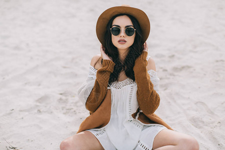 穿着棕色帽子的漂亮模特穿着嬉皮风格的白礼服在夏背景图片