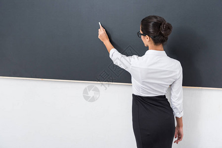 美丽的年轻老师在黑板图片