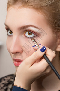 化妆艺术家在模特眼睛上应用明亮的底色双眼图片