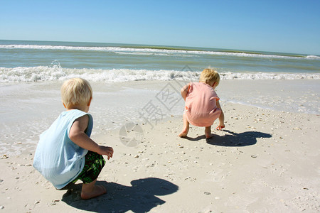 两个小孩一个男孩和他的小弟在海边的图片