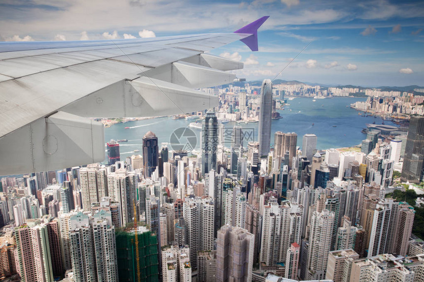 从飞机窗看香港九龙和机翼的顶视图刚从香港国际机场起飞图片