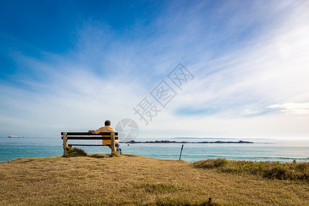 独自一人坐在沙滩上享受蔚蓝的大海图片