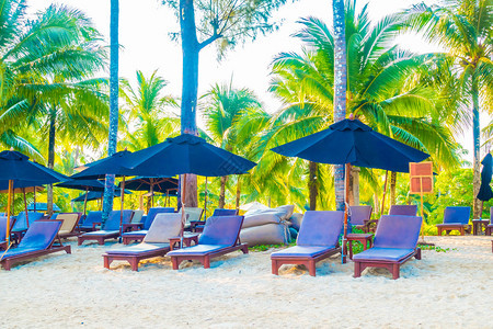 美丽的热带海滩和海洋景观上的雨伞和椅子图片