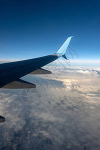 商业飞机飞机翼飞越云层上空图片