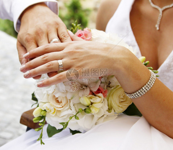 婚礼花束上的手和戒指图片