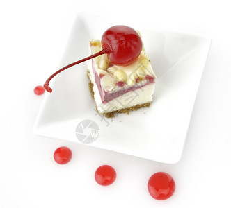 白盘子里的一片樱桃芝士蛋糕图片